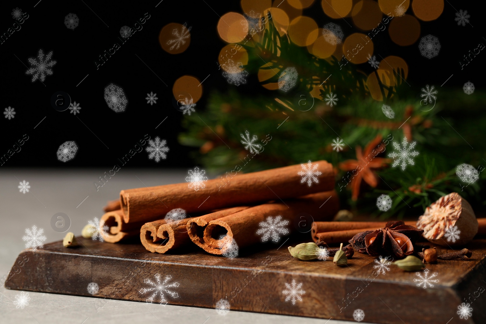 Image of Different spices and fir tree branches on grey table, closeup. Cinnamon, anise, cardamom, cloves, nutmeg