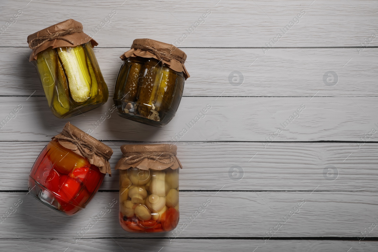 Photo of Jars with pickled vegetables on white wooden table, flat lay. Space for text