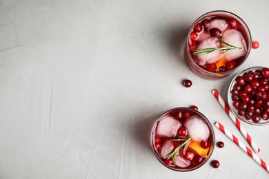 Tasty refreshing cranberry cocktail on light grey table, flat lay. Space for text