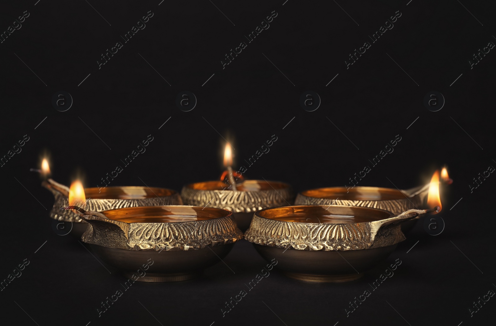 Photo of Diwali diyas or clay lamps on dark background