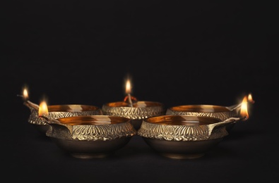 Photo of Diwali diyas or clay lamps on dark background