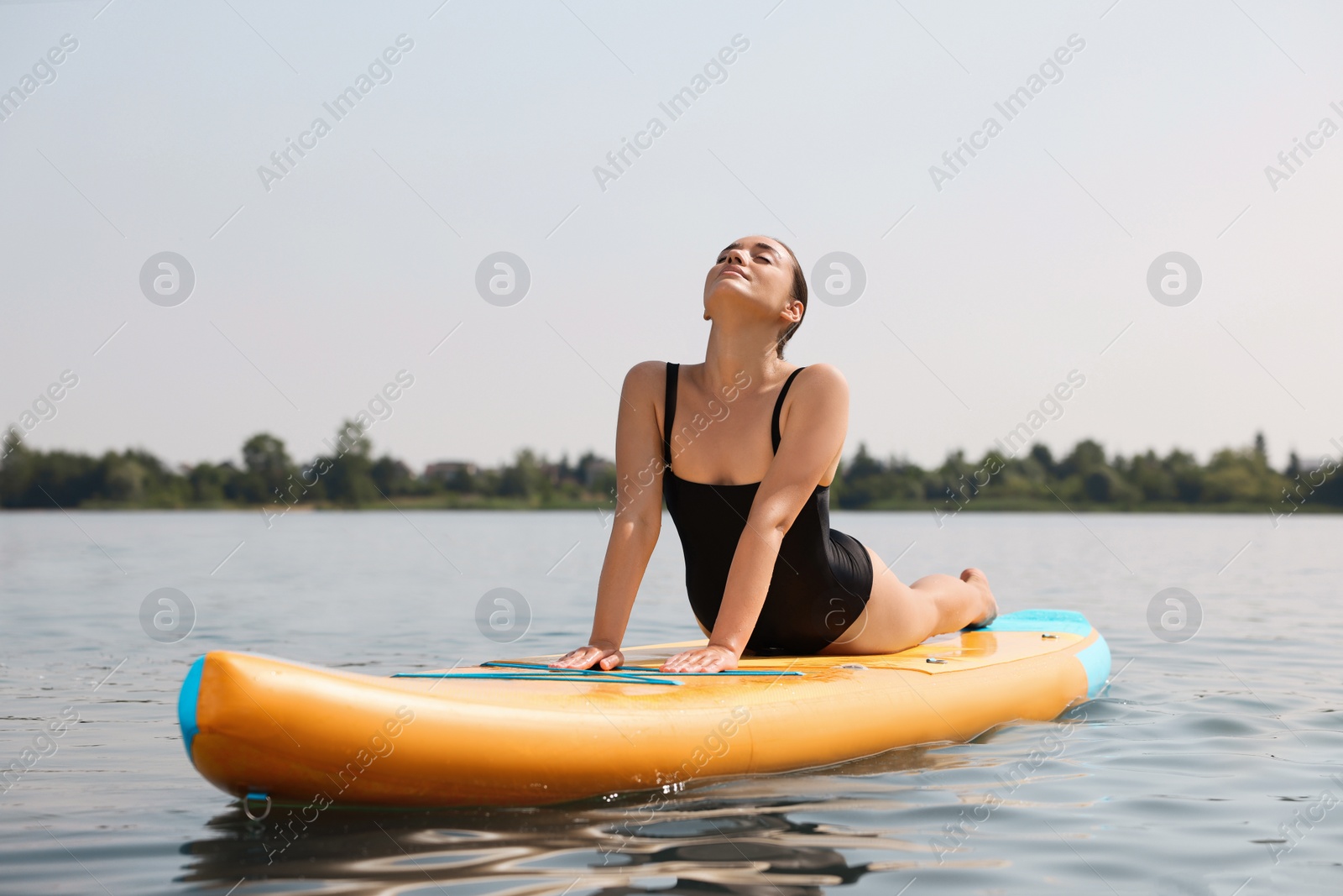 Photo of Woman practicing yoga on SUP board on river