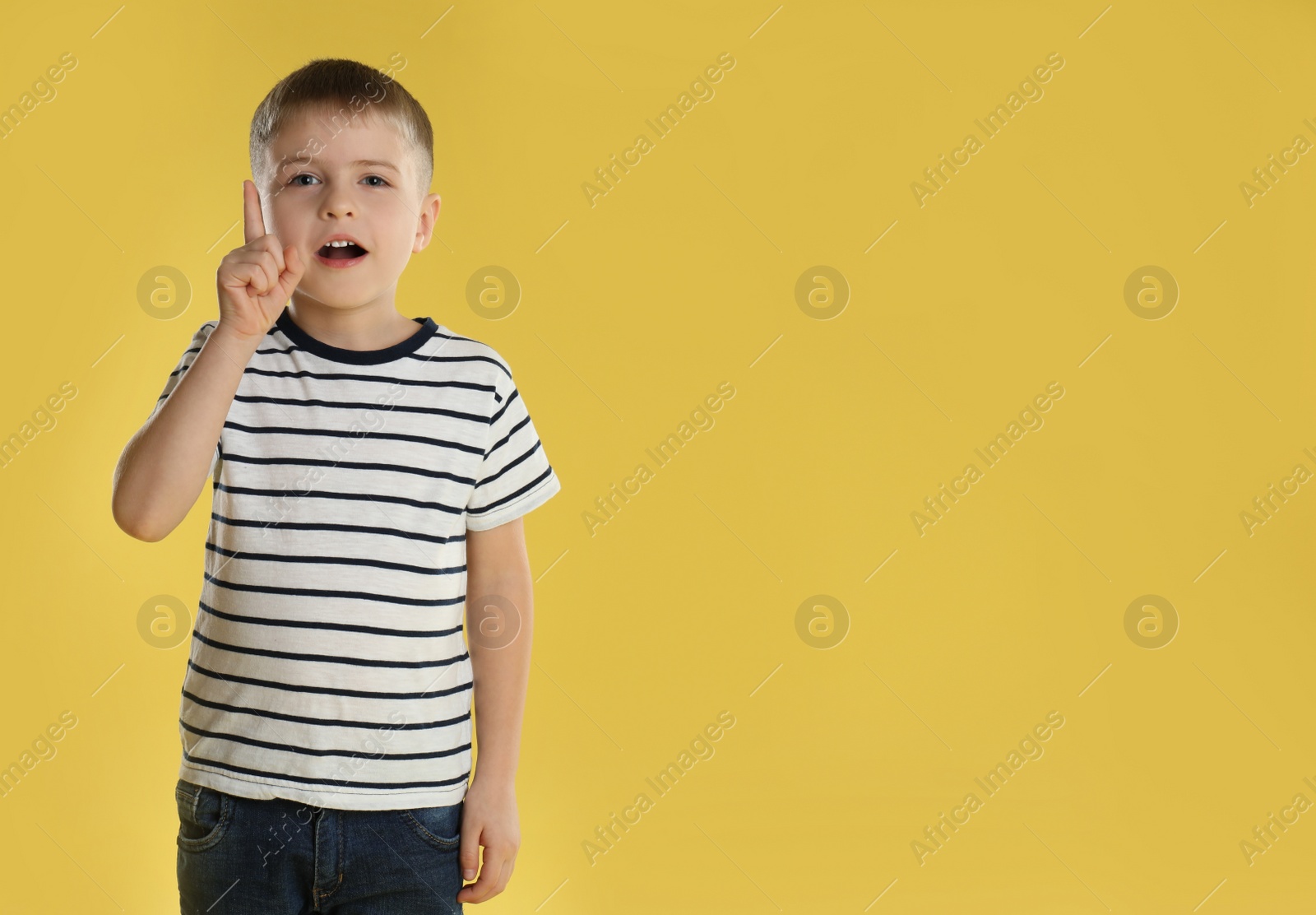 Photo of Portrait of little boy on yellow background. Space for text