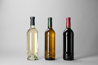 Photo of Bottles with different types of wine on light background