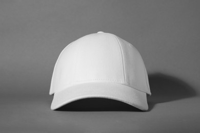 Photo of Stylish white baseball cap on grey background