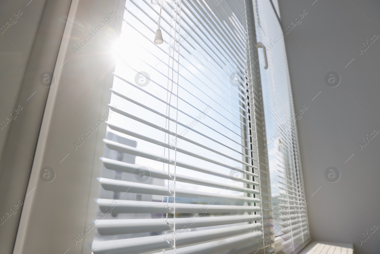 Photo of Stylish window with horizontal blinds in room