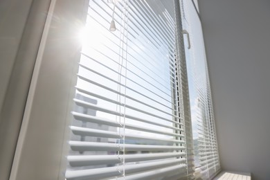 Stylish window with horizontal blinds in room