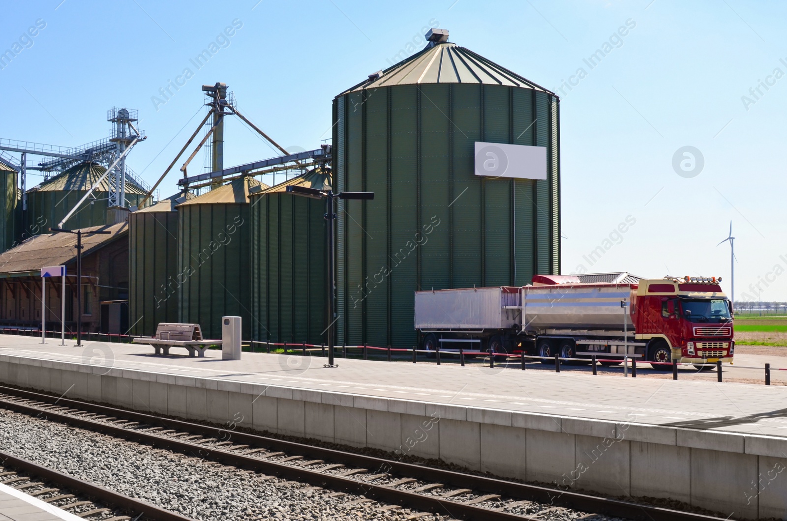 Photo of Silos near railway platform on sunny day