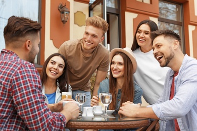 Photo of Happy people spending time together at outdoor cafe