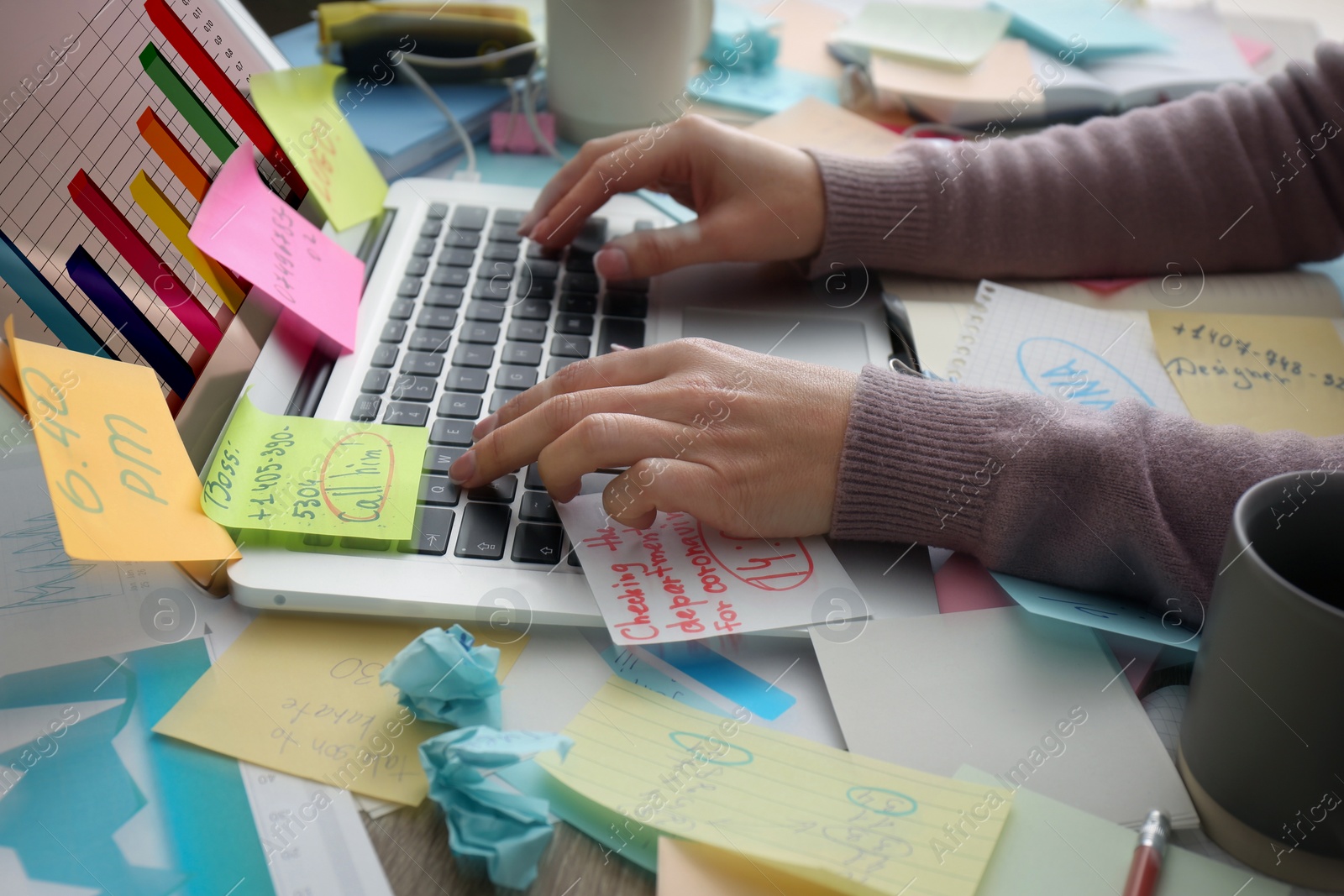 Photo of Overwhelmed woman working at messy office desk, closeup