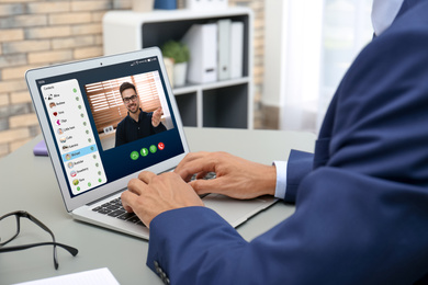 Man having online meeting with his colleague via laptop, closeup