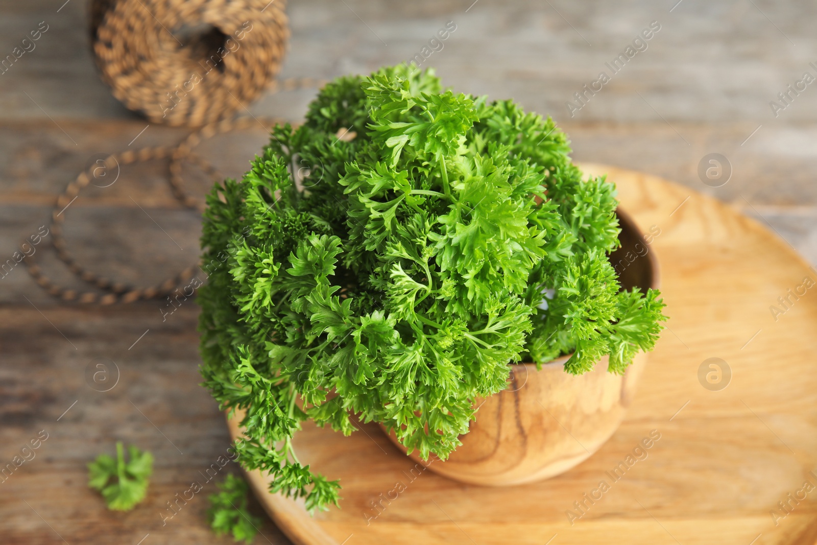 Photo of Bowl with fresh green parsley on table