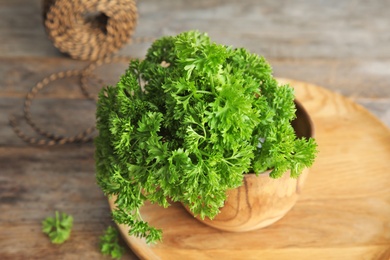 Photo of Bowl with fresh green parsley on table