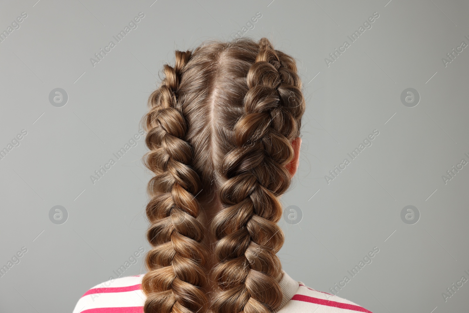 Photo of Woman with braided hair on grey background, back view