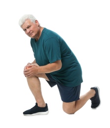 Full length portrait of senior man having knee problems on white background