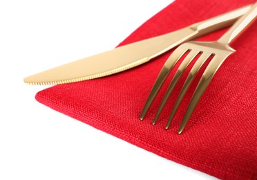 Photo of Red napkin with golden fork and knife on white background, closeup