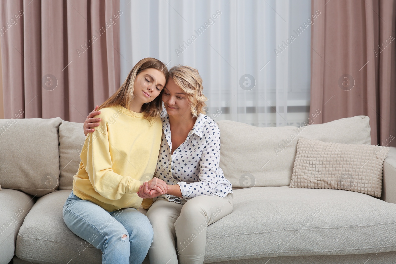 Photo of Young woman with her mom on sofa at home. Happy Mother's Day