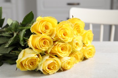 Beautiful bouquet of yellow roses on light grey table indoors, closeup