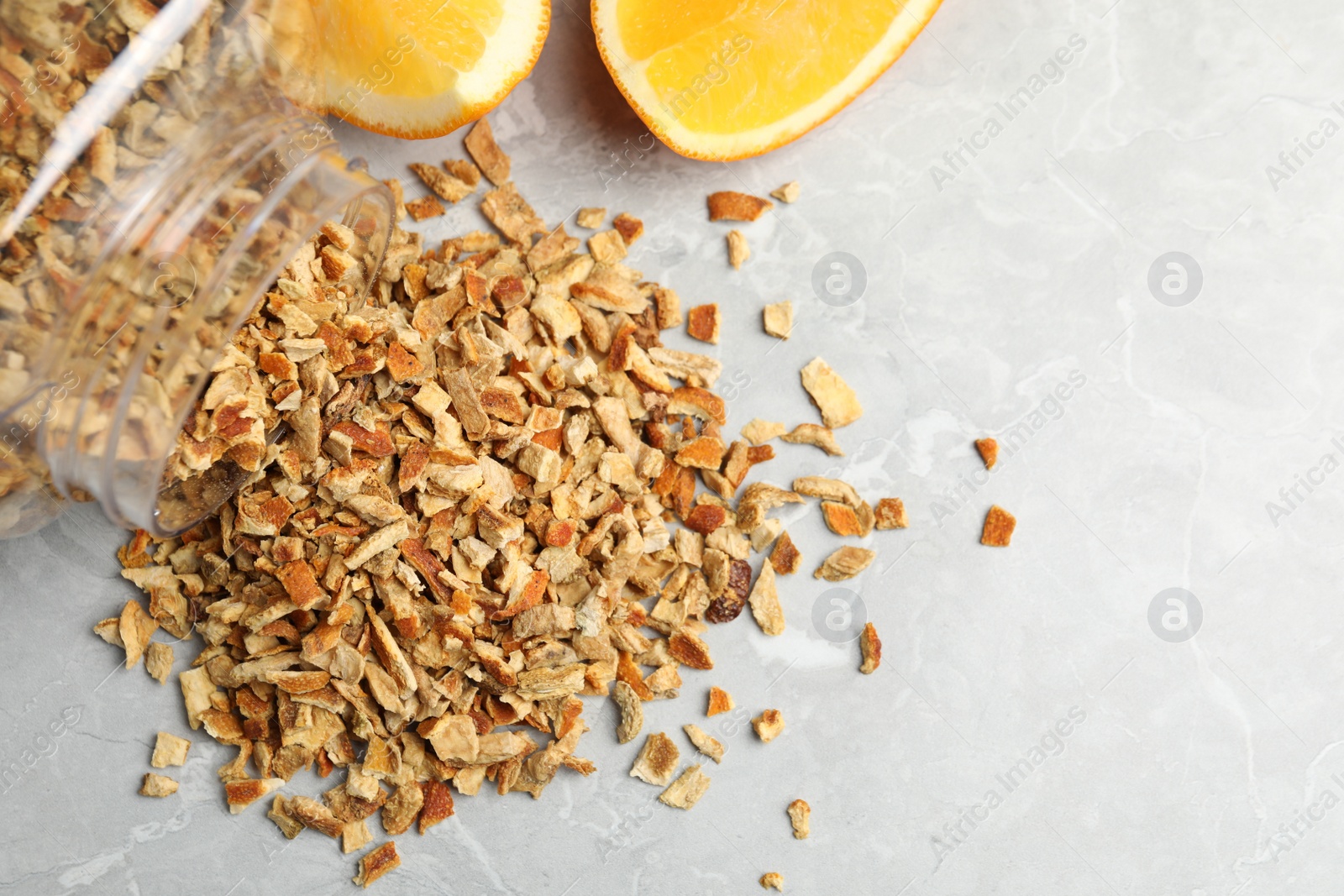 Photo of Jar with dried orange zest seasoning and fresh fruit on light grey table, flat lay. Space for text