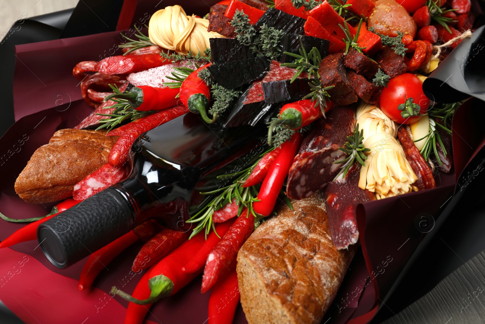 Photo of Beautiful edible bouquet with meat, cheese and vegetables on wooden table, closeup