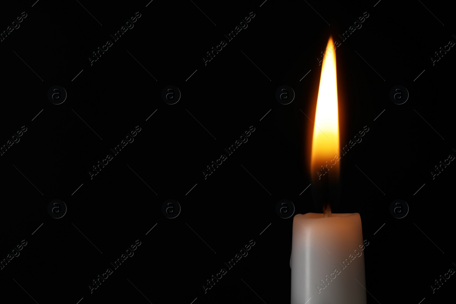 Photo of Burning candle on dark background, space for text. Symbol of sorrow