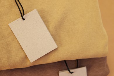 Photo of Cardboard tags on garment, closeup. Space for text