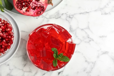 Photo of Flat lay composition with pomegranate jelly in bowl on marble table. Space for text