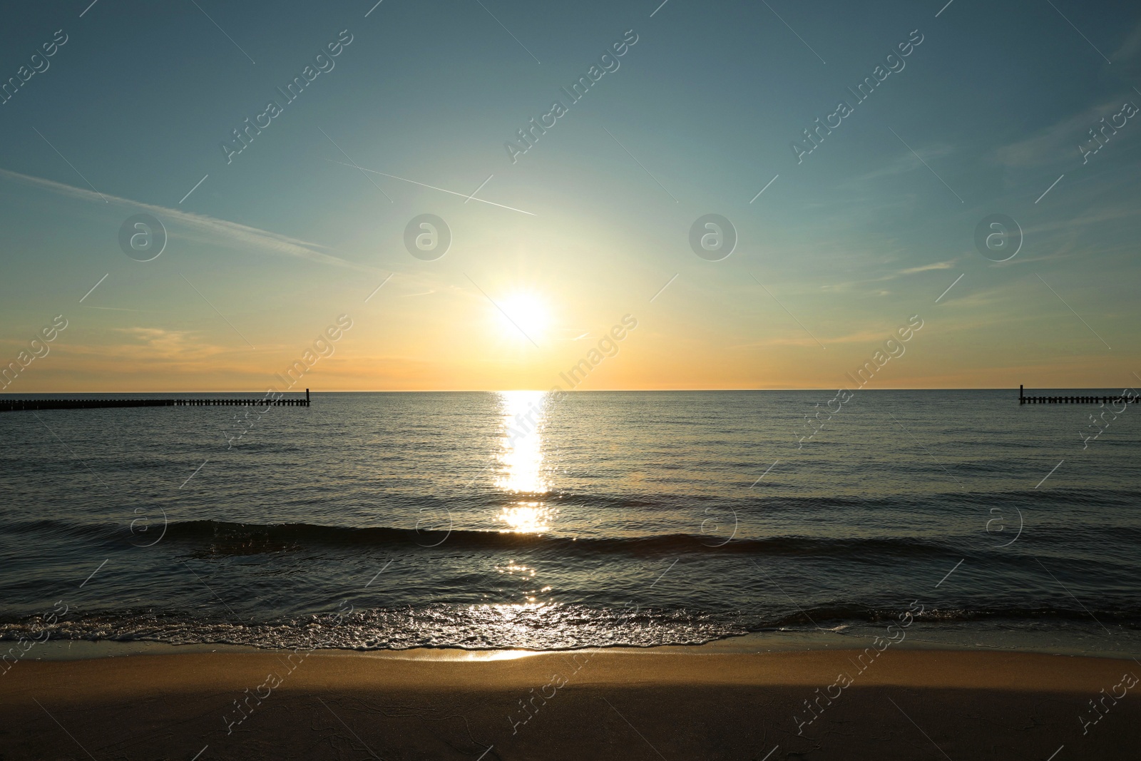 Picturesque view of sandy beach and sea at sunset Photo of Picturesque view of sandy beach and sea at sunset