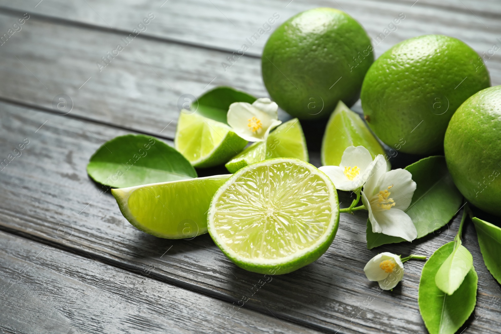 Photo of Fresh ripe limes on wooden table. Citrus fruit