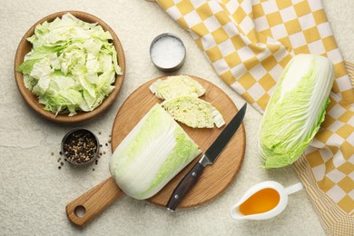 Photo of Fresh Chinese cabbages, oil and spices on light table, flat lay