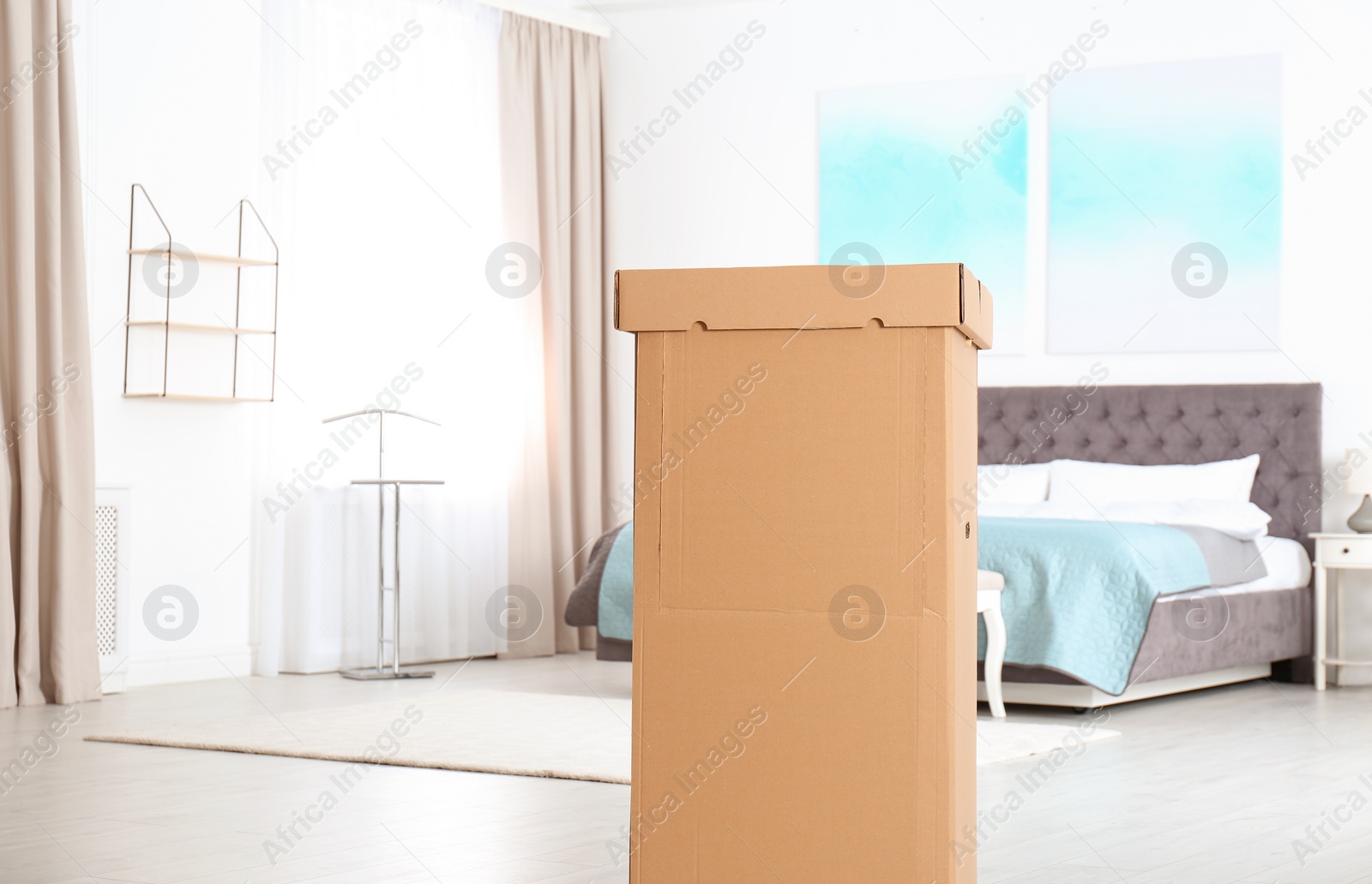 Photo of Cardboard wardrobe box in bedroom. Space for text