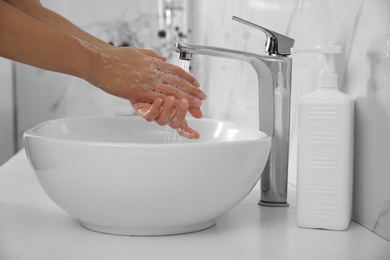 Photo of Woman washing hands with antibacterial soap indoors, closeup. Personal hygiene during COVID-19 pandemic