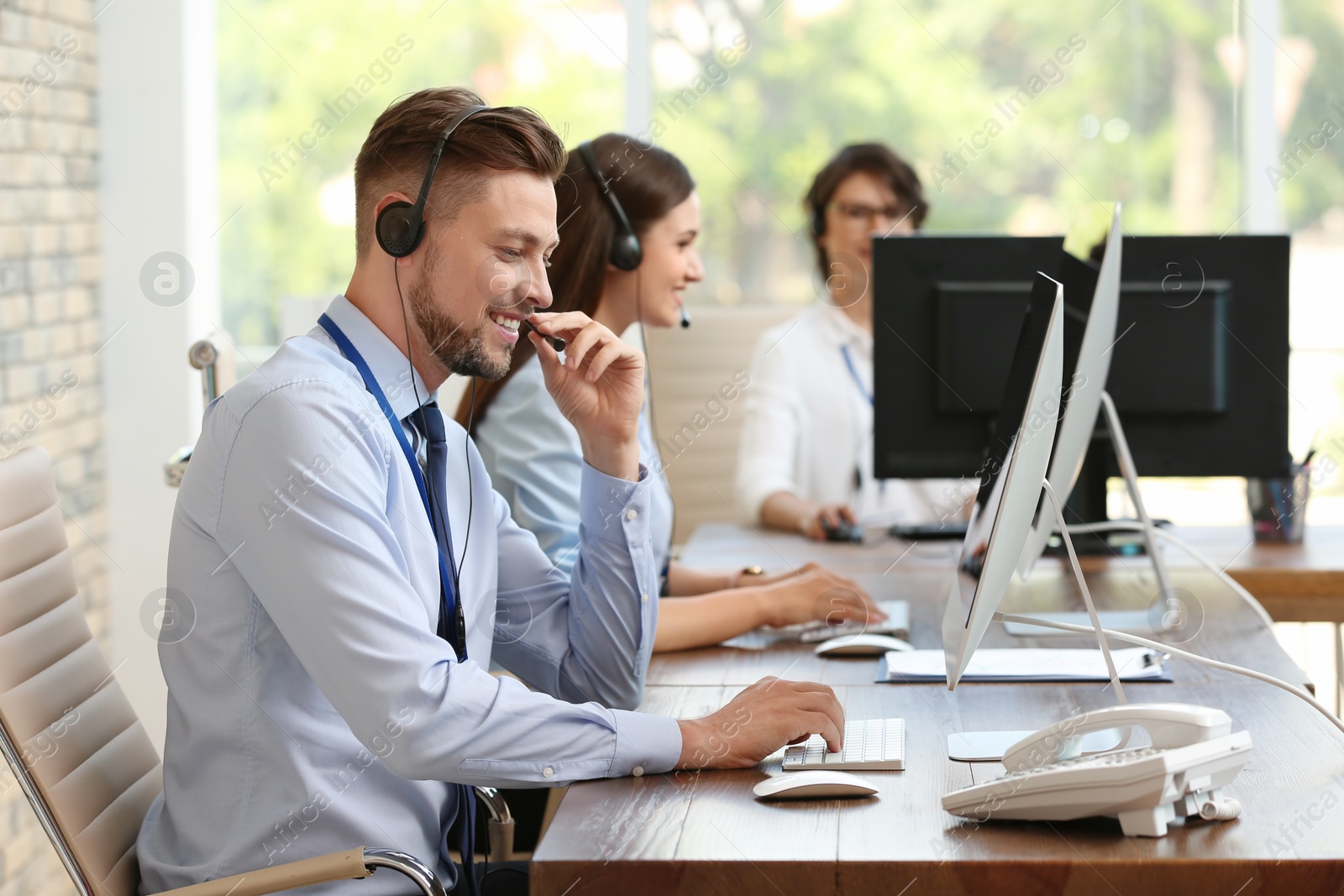 Photo of Technical support operators with headsets at workplace