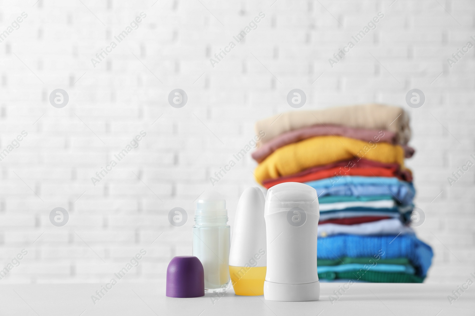 Photo of Different deodorants on white table. Space for text