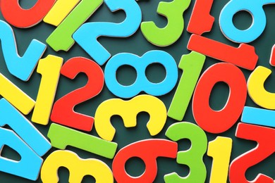 Photo of Colorful numbers on green background, top view