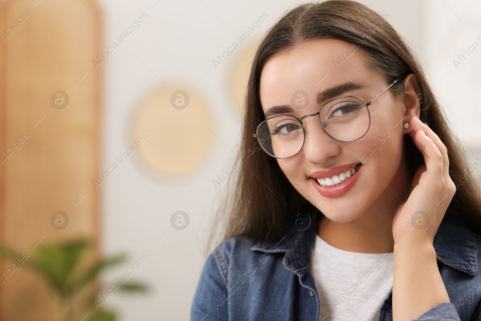 Photo of Portrait of beautiful young woman with glasses indoors, space for text. Attractive lady posing for camera