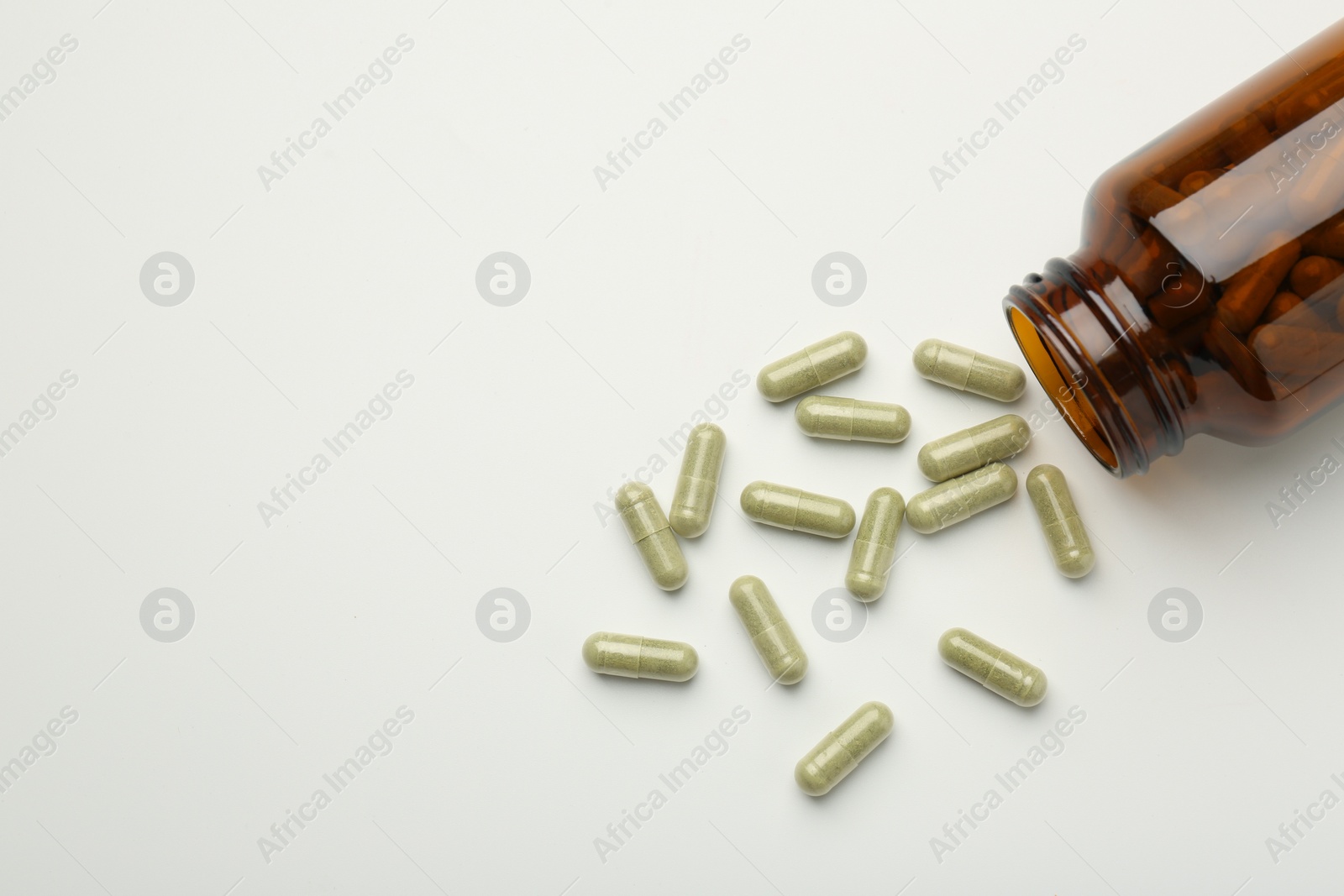 Photo of Bottle and vitamin capsules on white background, flat lay. Space for text