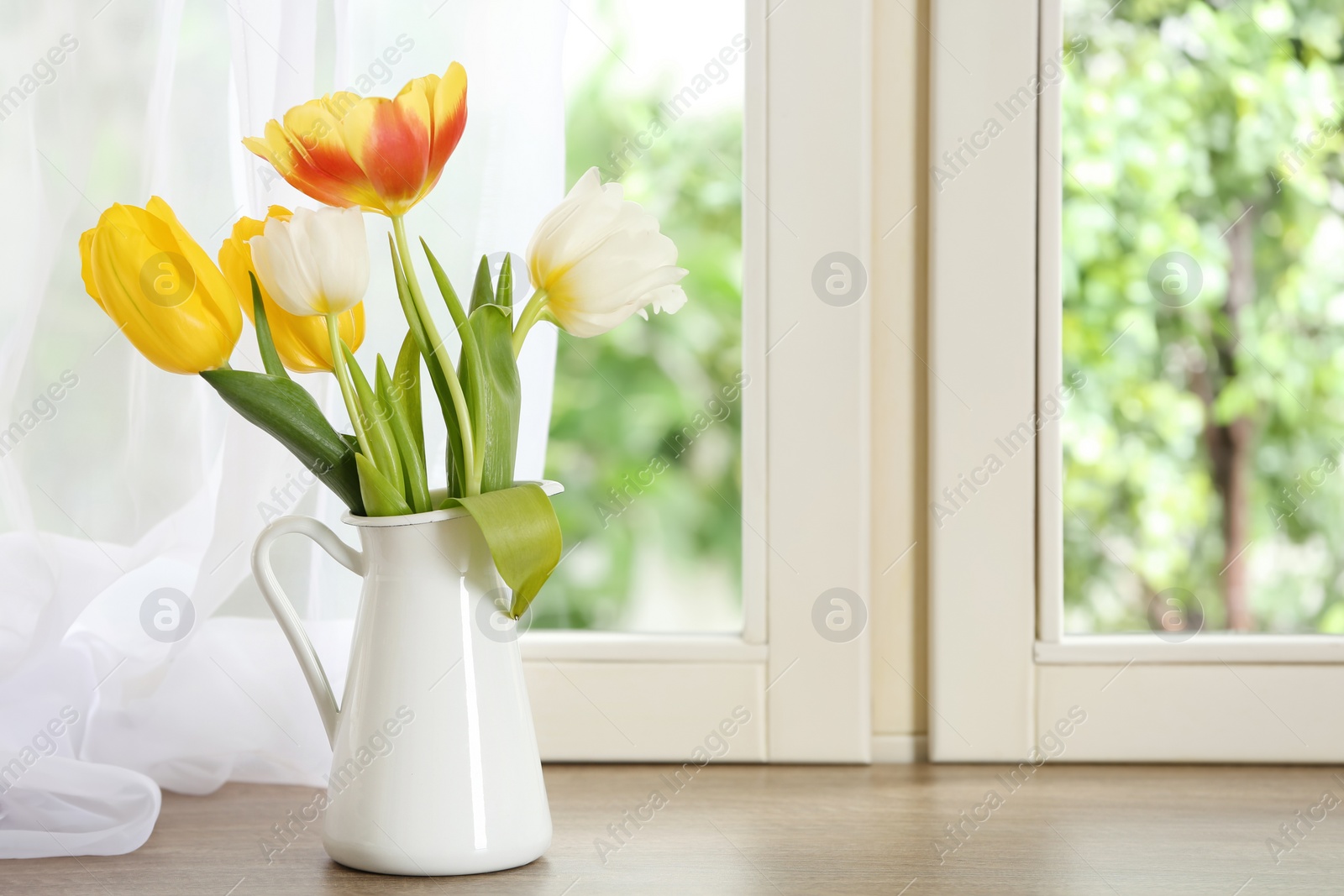 Photo of Beautiful fresh tulips on window sill indoors. Spring flowers