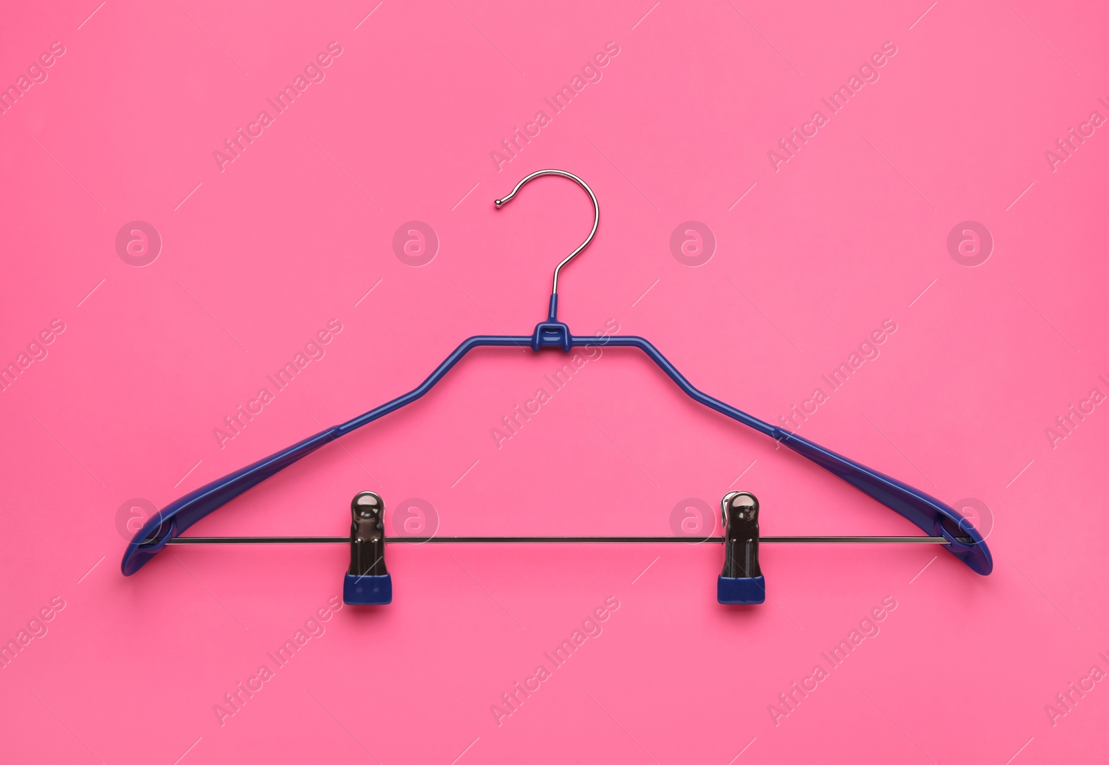 Photo of Empty hanger on pink background, top view