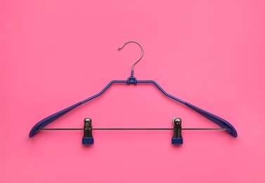 Empty hanger on pink background, top view