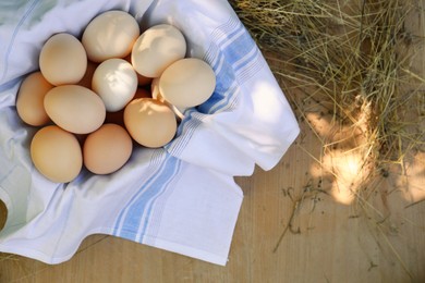 Photo of Fresh raw eggs on wooden table, top view. Space for text