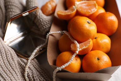Photo of Paper box with fresh ripe tangerines and decor, closeup