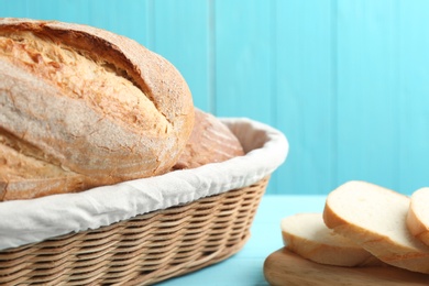 Tasty fresh bread on light blue wooden table, closeup