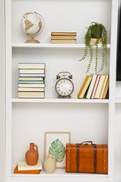 Photo of Books and different decorative elements on shelves indoors