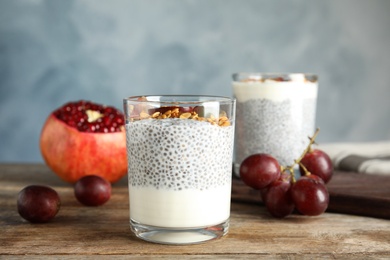 Tasty chia seed pudding with granola and ingredients on table