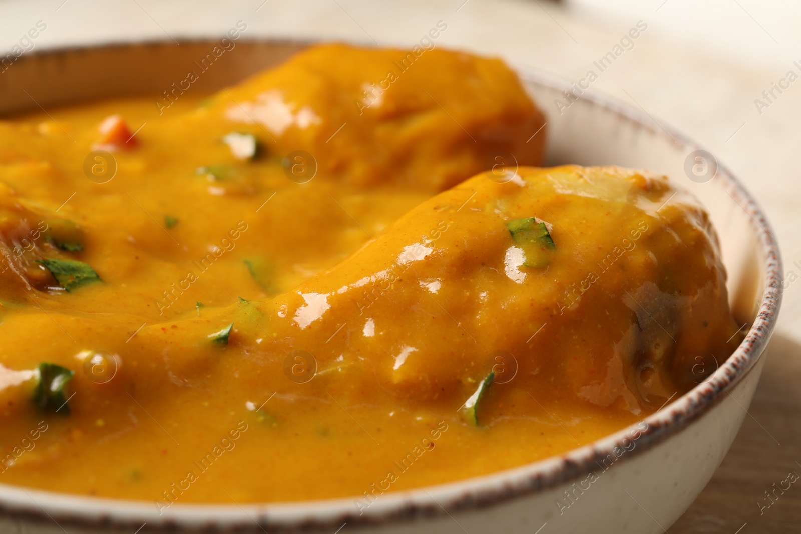 Photo of Tasty chicken curry in white bowl, closeup