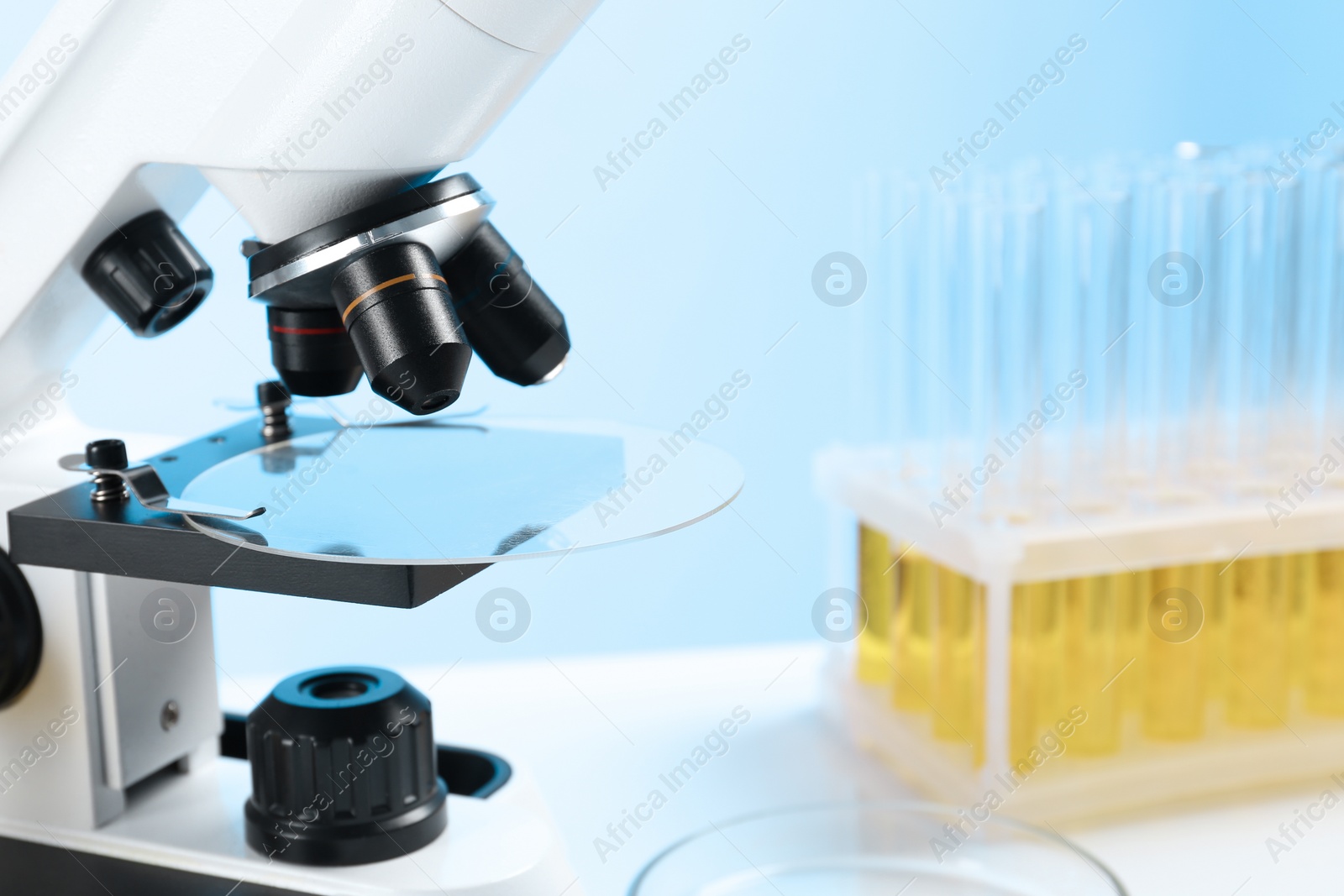 Photo of Microscope with glass slide on table in laboratory, space for text. Medical analysis