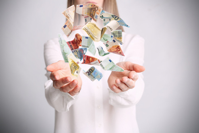 Woman with money on light grey background, closeup. Currency exchange