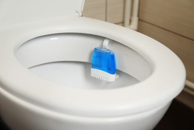 Photo of Toilet with rim block in bathroom. Air freshener