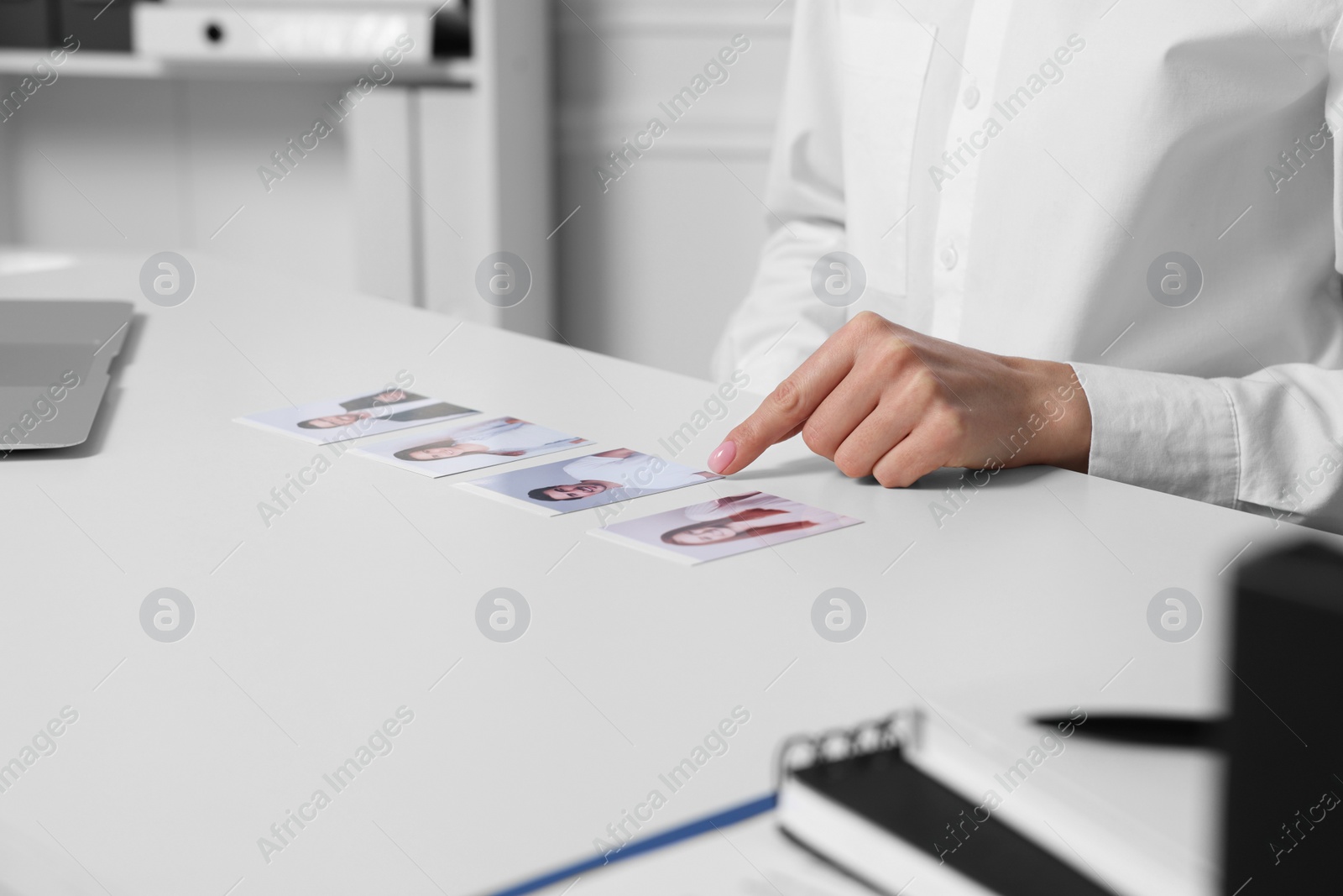 Photo of Human resources manager choosing employee among different applicants at table in office, closeup